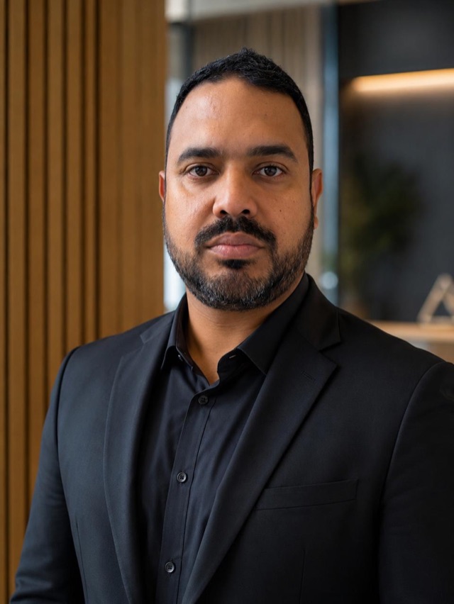 Jessé Seminio, fundador da Pensitec, de terno e camisa pretos, num escritório